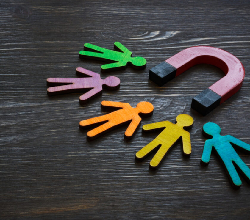 Magnet and figures of people. Customer acquisition and retention.